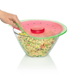 Glass bowl with watermelon lid being held by a hand on a white background