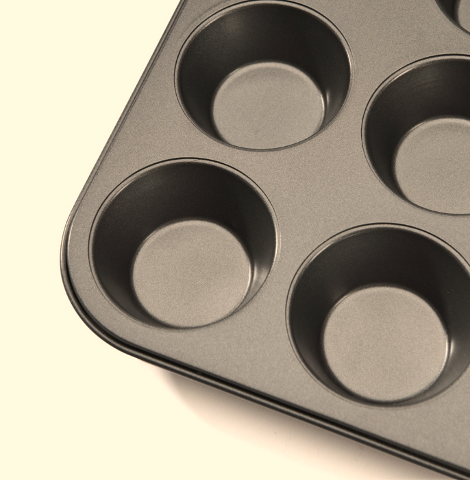 A close-up of the De Buyer non-stick muffin tray, shown at an angle on a white background.
