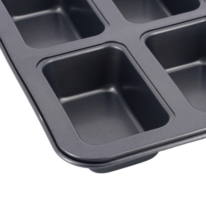 A close-up of a dark gray non-stick 6-compartment muffin or cupcake pan, showing the textured interior of the compartments and the raised rim, set against a plain white background.