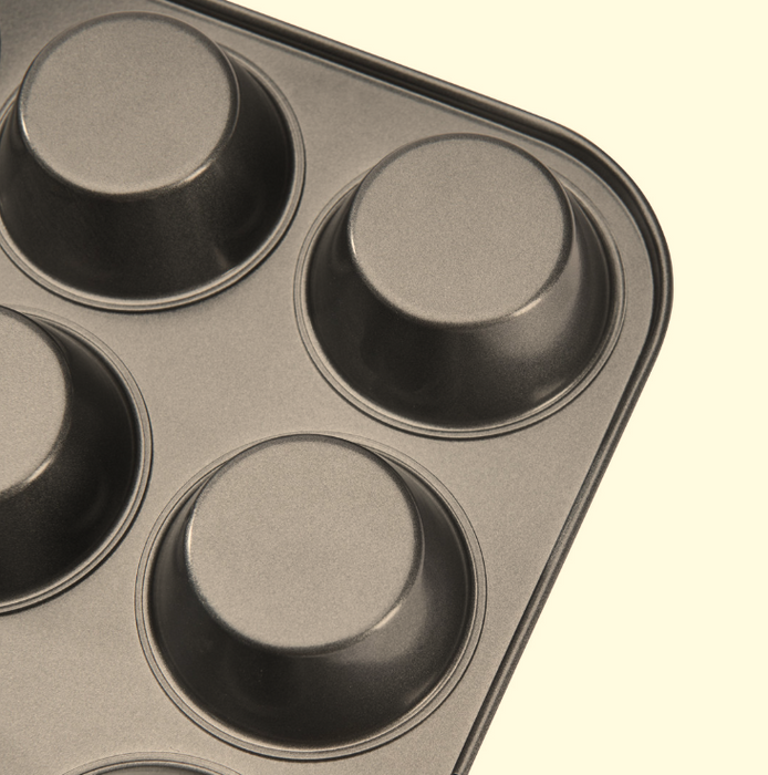 Close-up of the non-stick muffin tray with four visible cup compartments, on a white background.