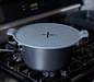 SCANPAN 24–32cm splatter guard protecting a saucepan from cooking splashes