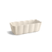 A rectangular ceramic baking pan with a scalloped fluted rim, shown on a clean white background with a soft shadow.